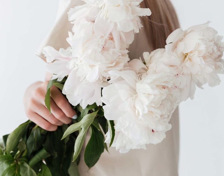 blonde-woman-standing-isolated-holding-flowers-P8B3XEP-1-scaled.jpg